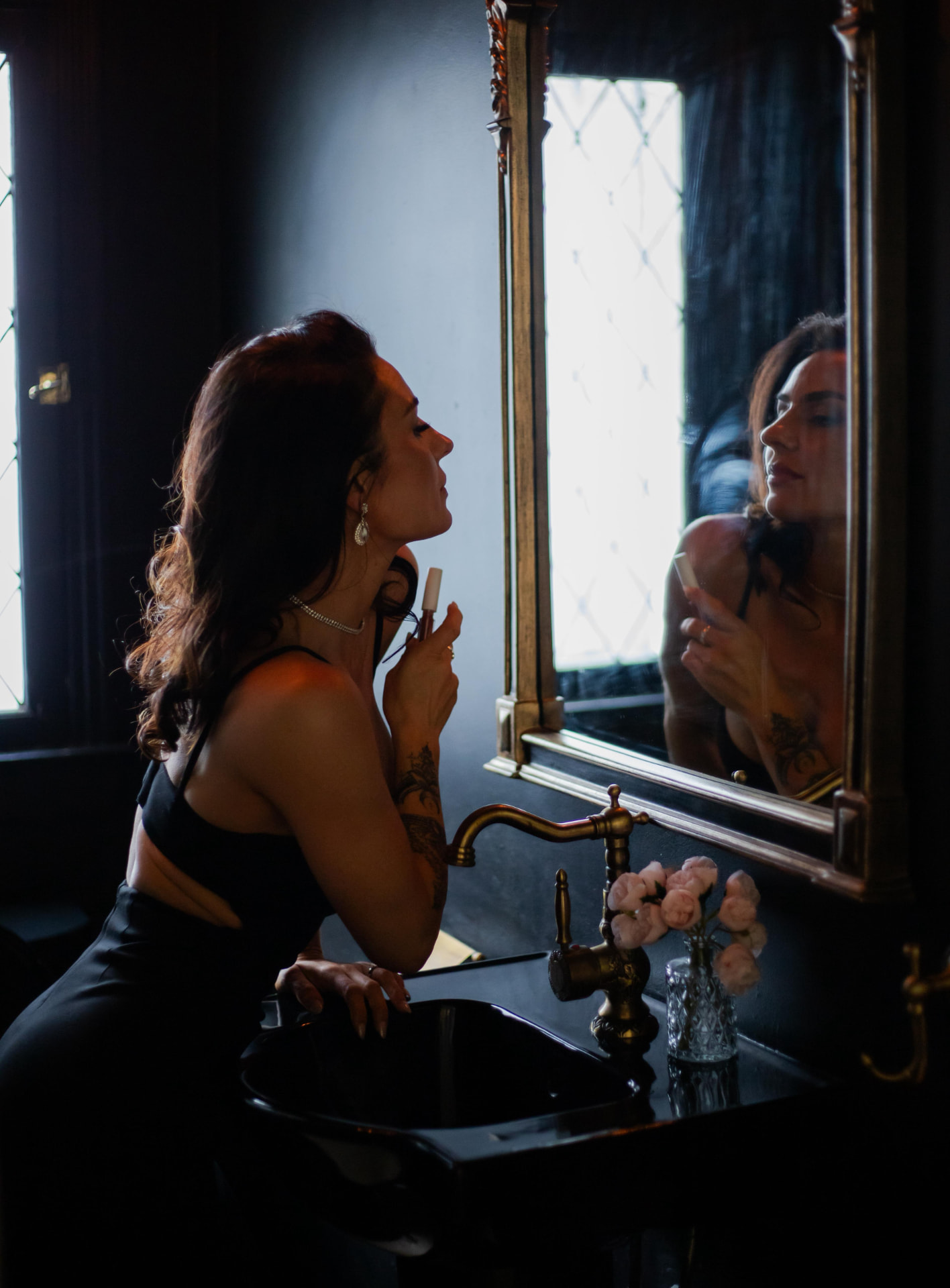 Natasha at a candlelit mirror in a dark room